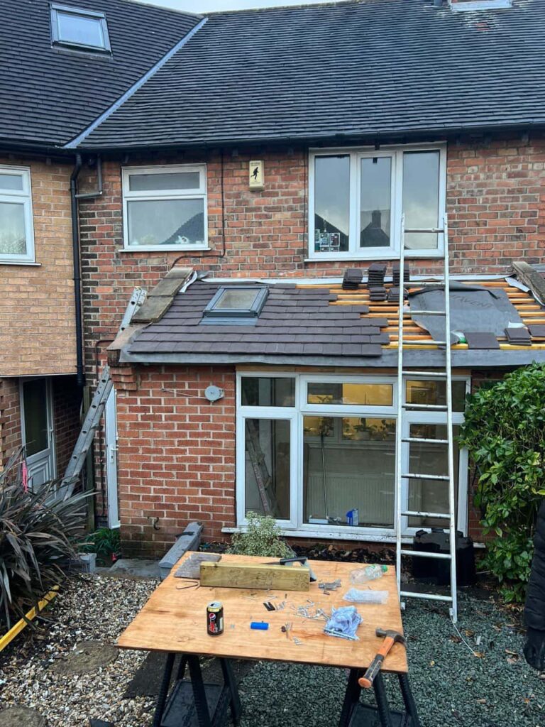 This is a photo of a roof extension that is having new roof tiles installed. This is a photo taken from the roof ridge looking down a tiled pitched roof on to a flat roof. Works carried out by Saxilby Roofing Repairs