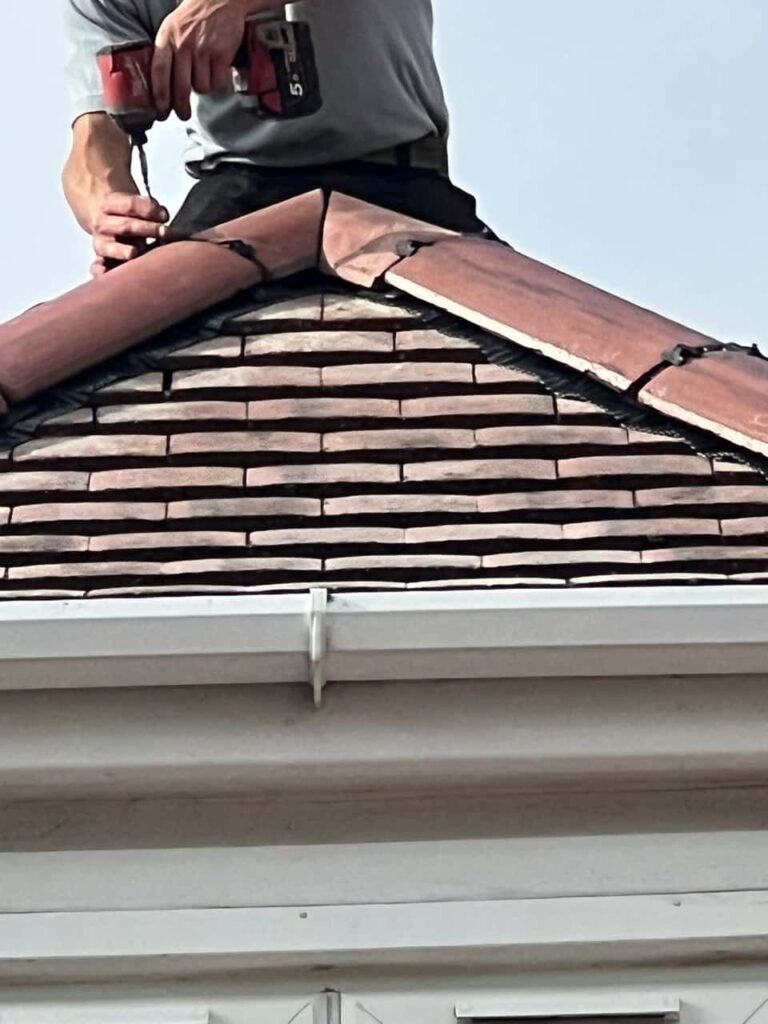 This is a photo of one of the operatives of Saxilby Roofing Repairs installing new ridge tiles